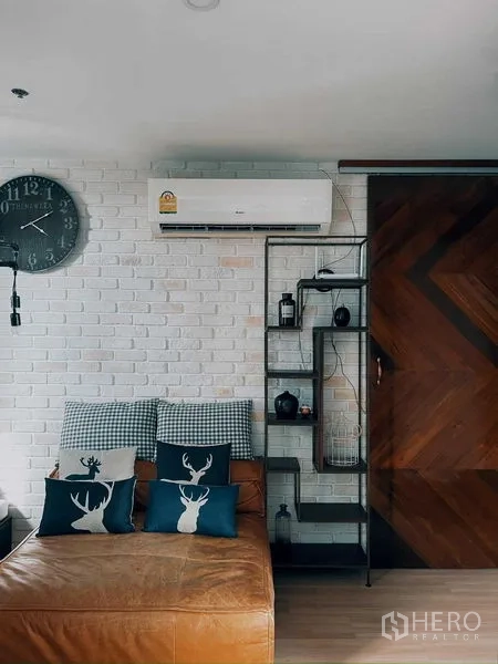 Condominium for rent in Suan Luang, Bangkok - Living area featuring white brick wall, air conditioner, and metal shelving