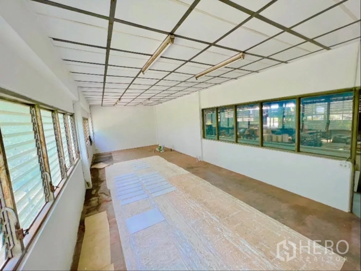 Factory for rent in Sai Noi, Nonthaburi - Office workspace with windows overlooking the production area.