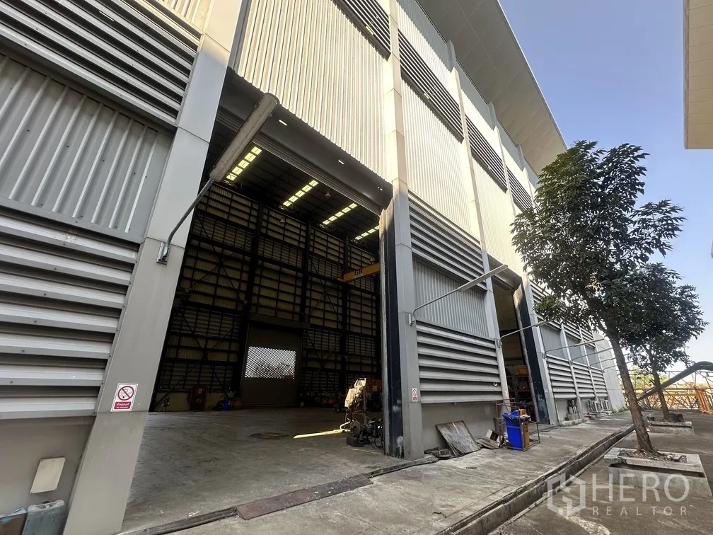 工厂 for rent in Lam Luk Ka, Pathum Thani - 高跨厂房外立面，宽幅卷帘门开启。