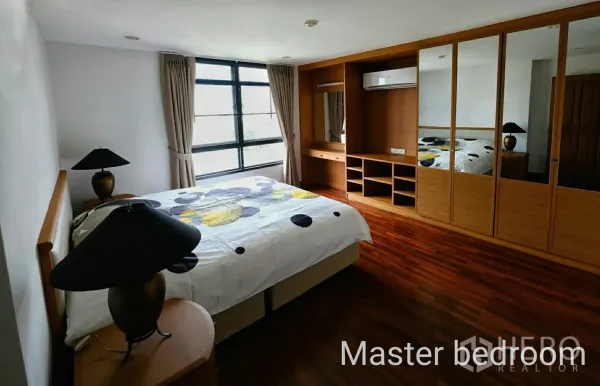 公寓 出租在Watthana, Bangkok - 主卧，采光充足的大窗与整面墙镜门衣柜