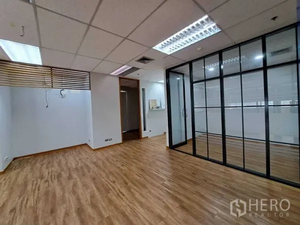Office Space for rent in Bang Rak, Bangkok - Open‑plan office with wood flooring, drop ceiling lighting and a glass meeting room.