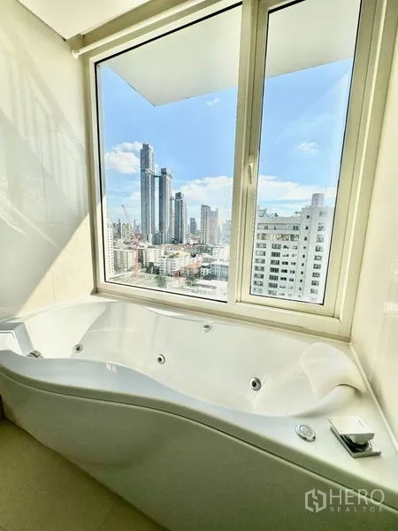 Condominium for rent in Watthana, Bangkok - Window-side jetted bathtub overlooking the city skyline.