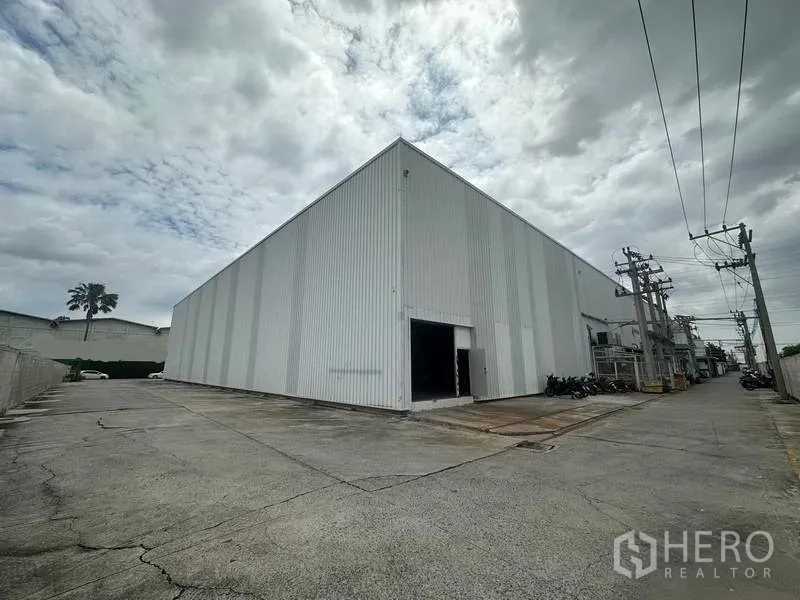 Factory for rent in Khlong Luang, Pathum Thani - Side elevation of the factory with service lane and secondary loading door.