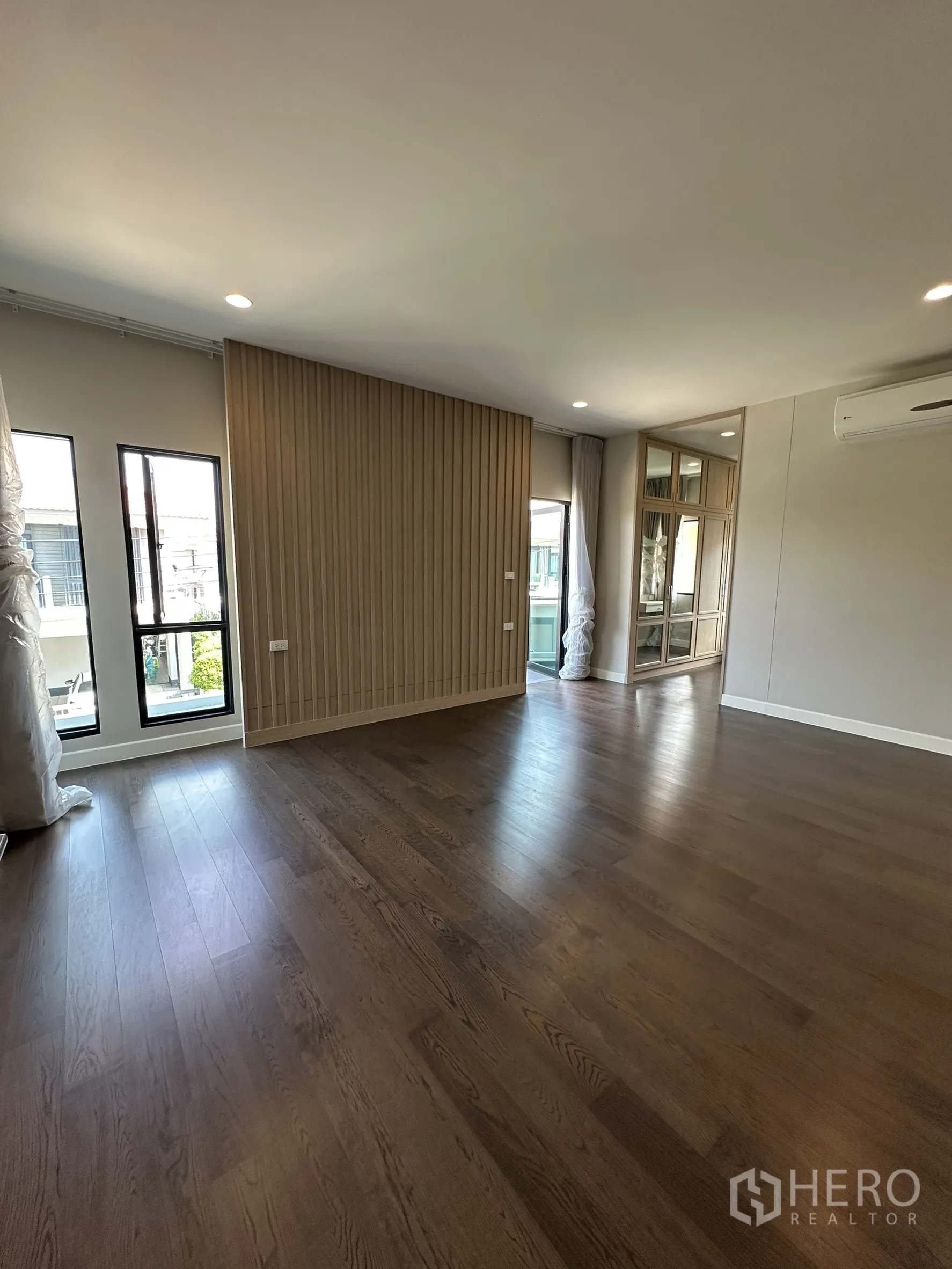 Detached House for sale in Lam Luk Ka, Pathum Thani - Spacious master bedroom with wood floors, slatted partition and glass wardrobe niche.