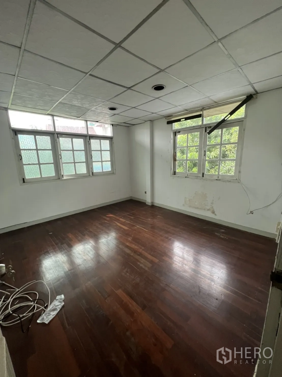 独立式住宅 出租或出售在Sathon, Bangkok - 无家具卧室，木地板与双窗，景观为绿意。