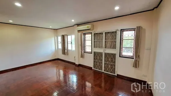 联排别墅 出租在Watthana, Bangkok - 室内宽敞房间，实木地板，多扇窗户，空调与防盗窗