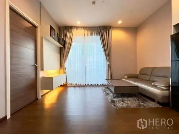 คอนโด ขายในRatchathewi, Bangkok - พื้นที่นั่งเล่นพร้อมโซฟา โต๊ะกลาง และประตูกระจกบานเลื่อนพร้อมผ้าม่าน
