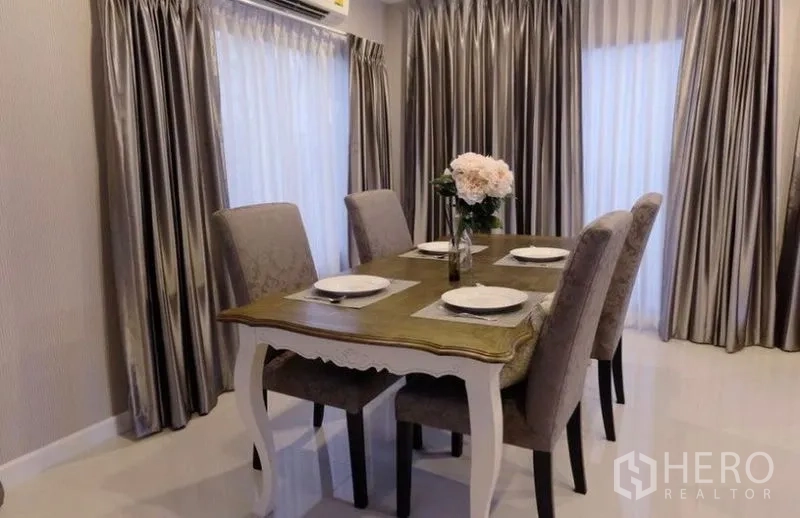 บ้าน ให้เช่าในSuan Luang, Bangkok - ห้องทานอาหารอบอุ่น โต๊ะ 4 ที่นั่ง เก้าอี้บุนวม และผ้าม่านเต็มบาน