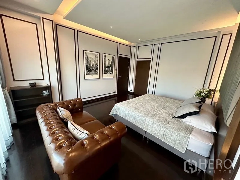 Detached House for rent - Spacious bedroom with feature wall, leather chesterfield sofa and a queen bed.