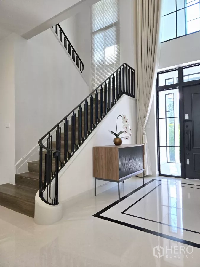 独立式住宅 出租在Saphan Sung, Bangkok - 挑高玄关，现代楼梯与高窗。