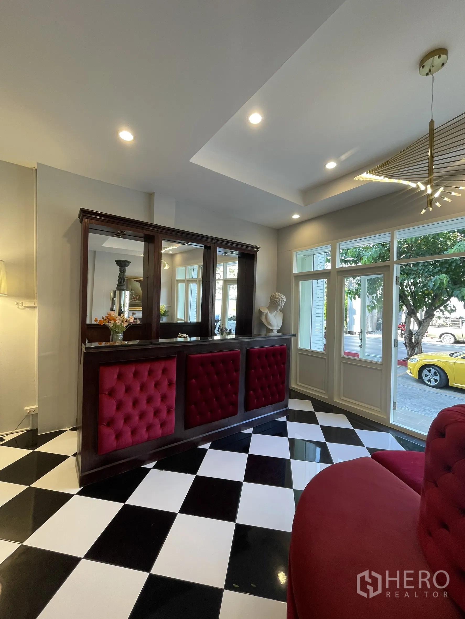 店屋 for rent in Bang Kapi, Bangkok - 临窗接待吧台，红色软包面板与黑白地砖。
