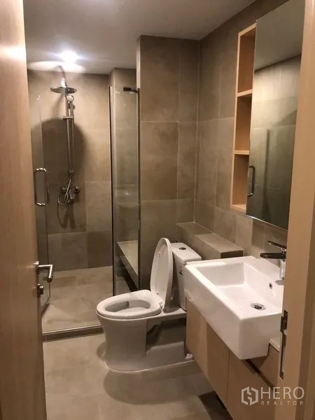 公寓 出租或出售在Yan Nawa, Bangkok - 浴室另一视角，玻璃淋浴房、坐便器与壁龛。