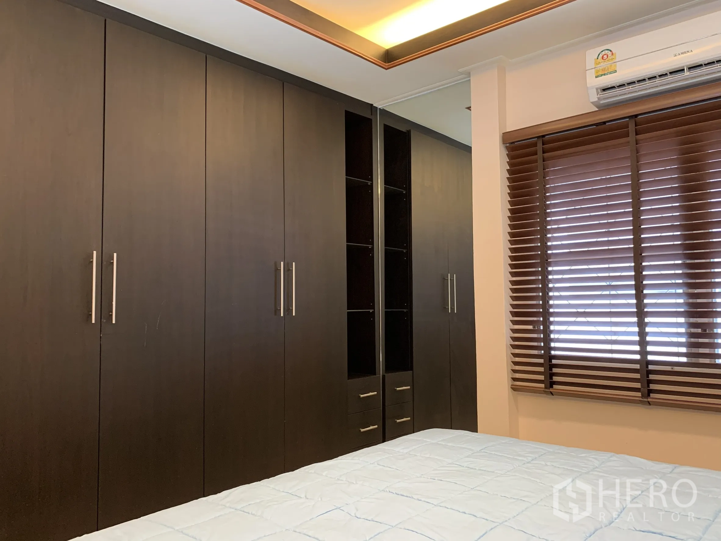独栋房屋 for rent in Saphan Sung, Bangkok - 主卧配大床、墙面装饰画与木百叶窗。