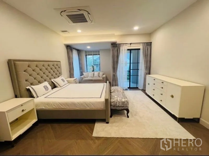 Detached House for rent or sale in Saphan Sung, Bangkok - Large master bedroom with sitting area, balcony access and herringbone wood floors.