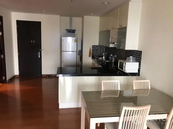 Condominium for rent in Ratchathewi, Bangkok - Open kitchen with black stone countertop, mosaic backsplash and dining table.