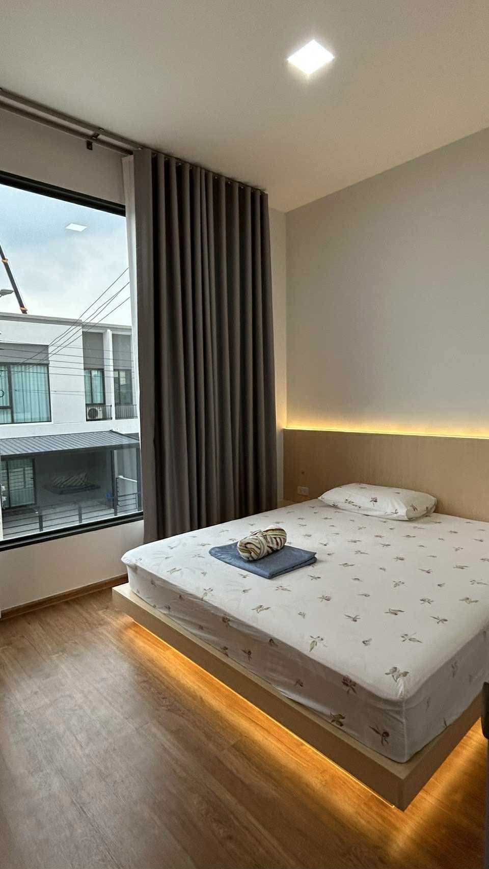 ทาวน์เฮาส์ ให้เช่าในBang Phli, Samut Prakan - ห้องนอนอบอุ่น เตียงมีไฟใต้เตียง หน้าต่างบานใหญ่เห็นวิวหมู่บ้าน.