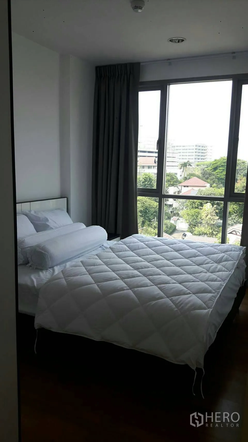 Condominium for rent in Phaya Thai, Bangkok - Bedroom with double bed, large windows and green neighborhood outlook in Phaya Thai.