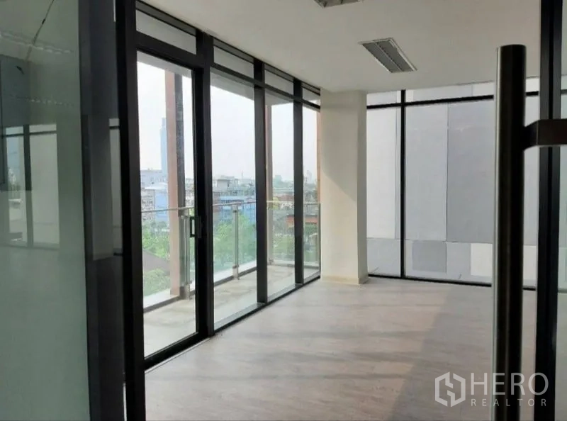 Office Space for rent in Bang Kho Laem, Bangkok - Glass-walled meeting area with sliding doors to a small balcony and city view.