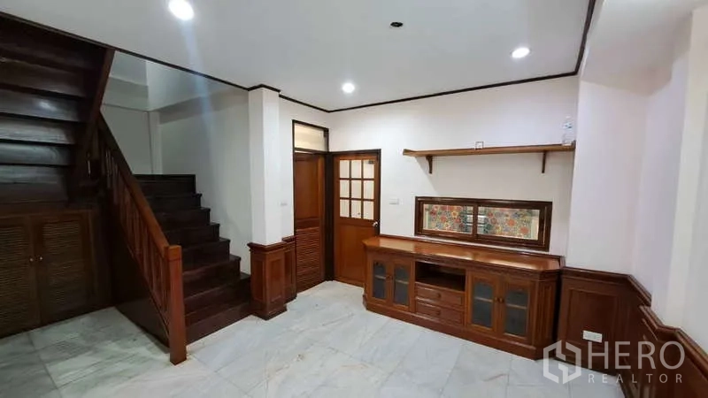 联排别墅 出租在Watthana, Bangkok - 木楼梯与扶手，中间平台，白墙