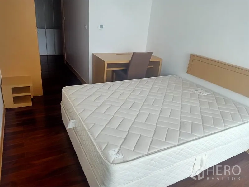 公寓 出租在Watthana, Bangkok - 宽敞卧室，木地板、双人床与书桌。