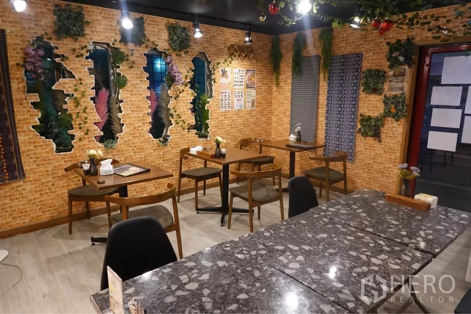 Retail Space for rent in Watthana, Bangkok - Dining area featuring marble tables, spot lighting, and a decorative brick feature wall.