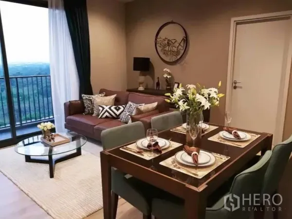 公寓 出租在Chatuchak, Bangkok - 开放式客餐厅，四人餐桌、沙发与推拉门通向阳台。