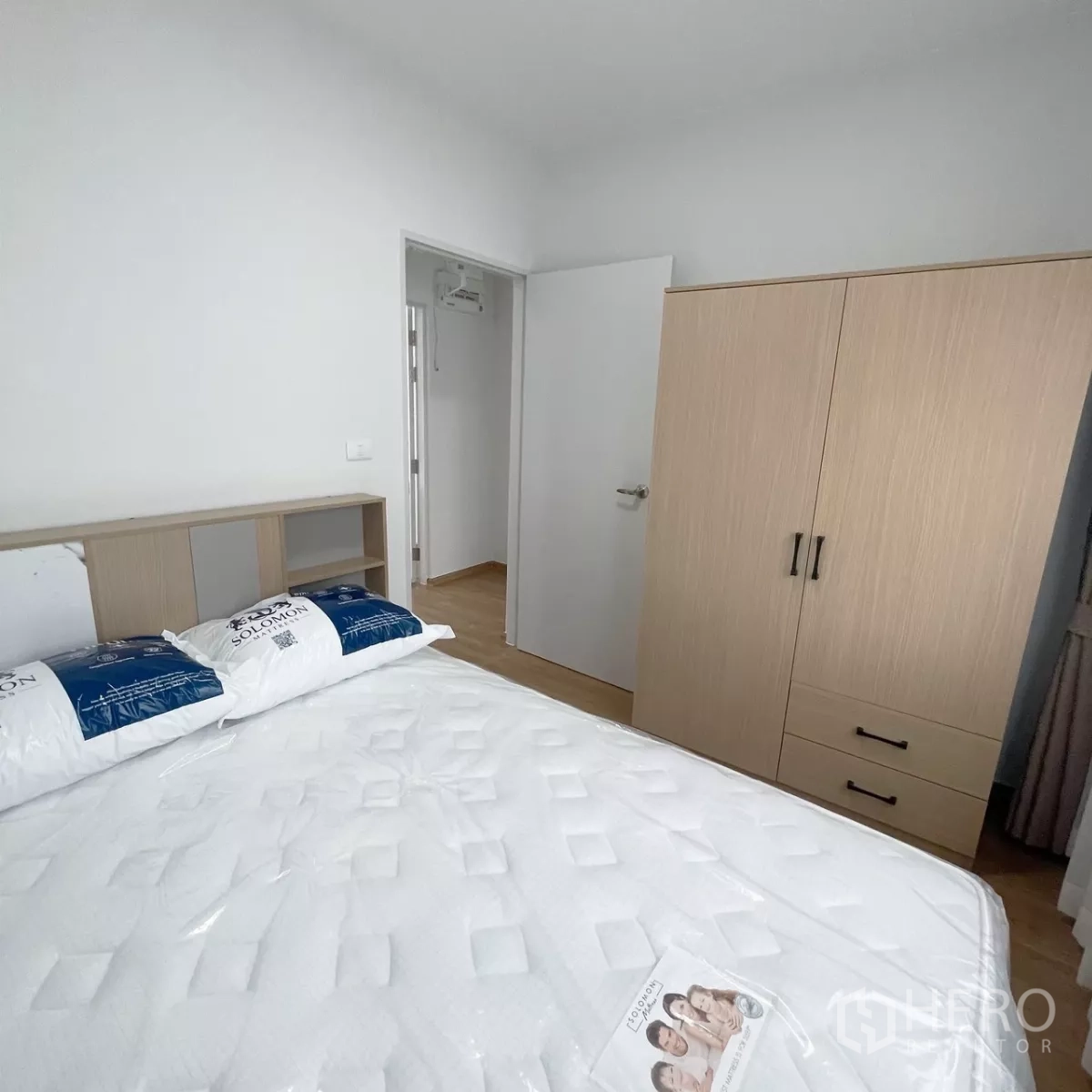 Townhouse for rent in Bang Phli, Samut Prakan - Cozy second bedroom with bed, wardrobe and white walls.