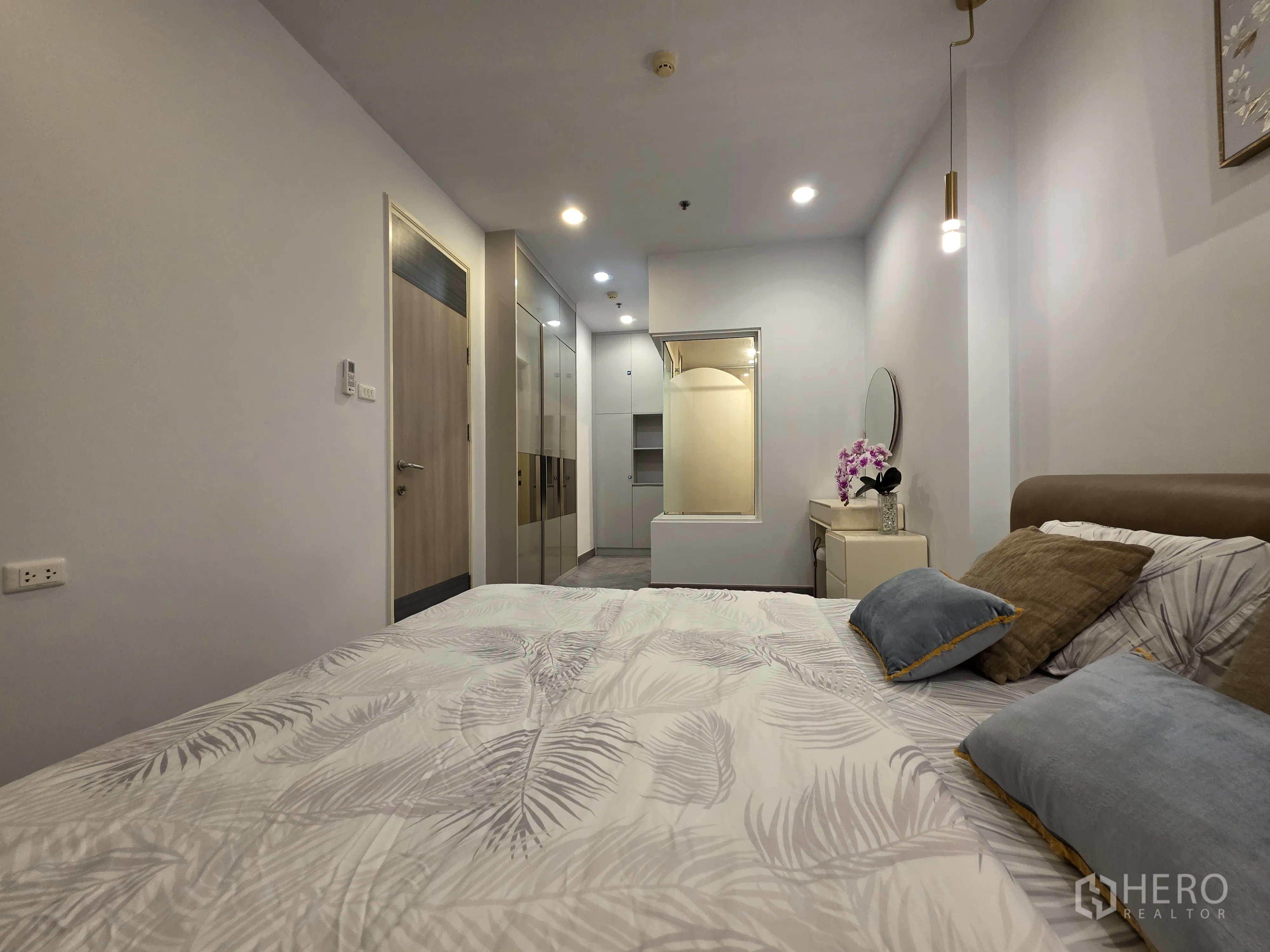 公寓 for rent in Bang Kapi, Bangkok - 卧室朝衣柜与入户门方向的视角，灯光柔和。