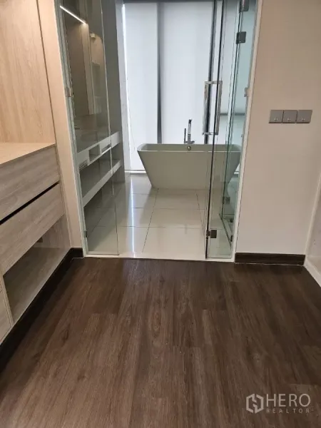 公寓 出租在Watthana, Bangkok - 现代浴室，玻璃门、盥洗台与靠窗的独立式浴缸。