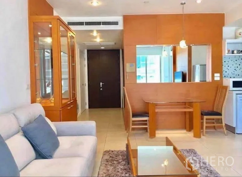 公寓 出租或出售在Ratchathewi, Bangkok - 開放式客餐廳，設有沙發、玻璃展示櫃與吊燈。