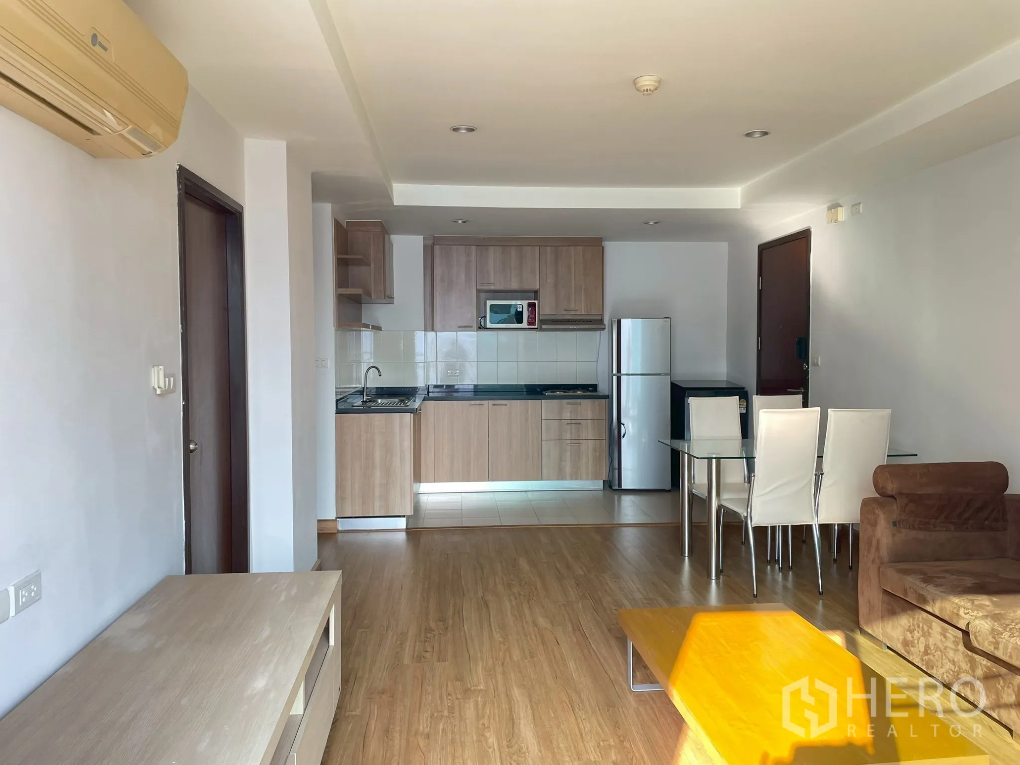 อพาร์ทเมนท์ for rent in Khlong Toei, Bangkok - โถงนั่งเล่นมองไปยังครัว พร้อมโซฟา โต๊ะกลาง และชุดทานอาหาร