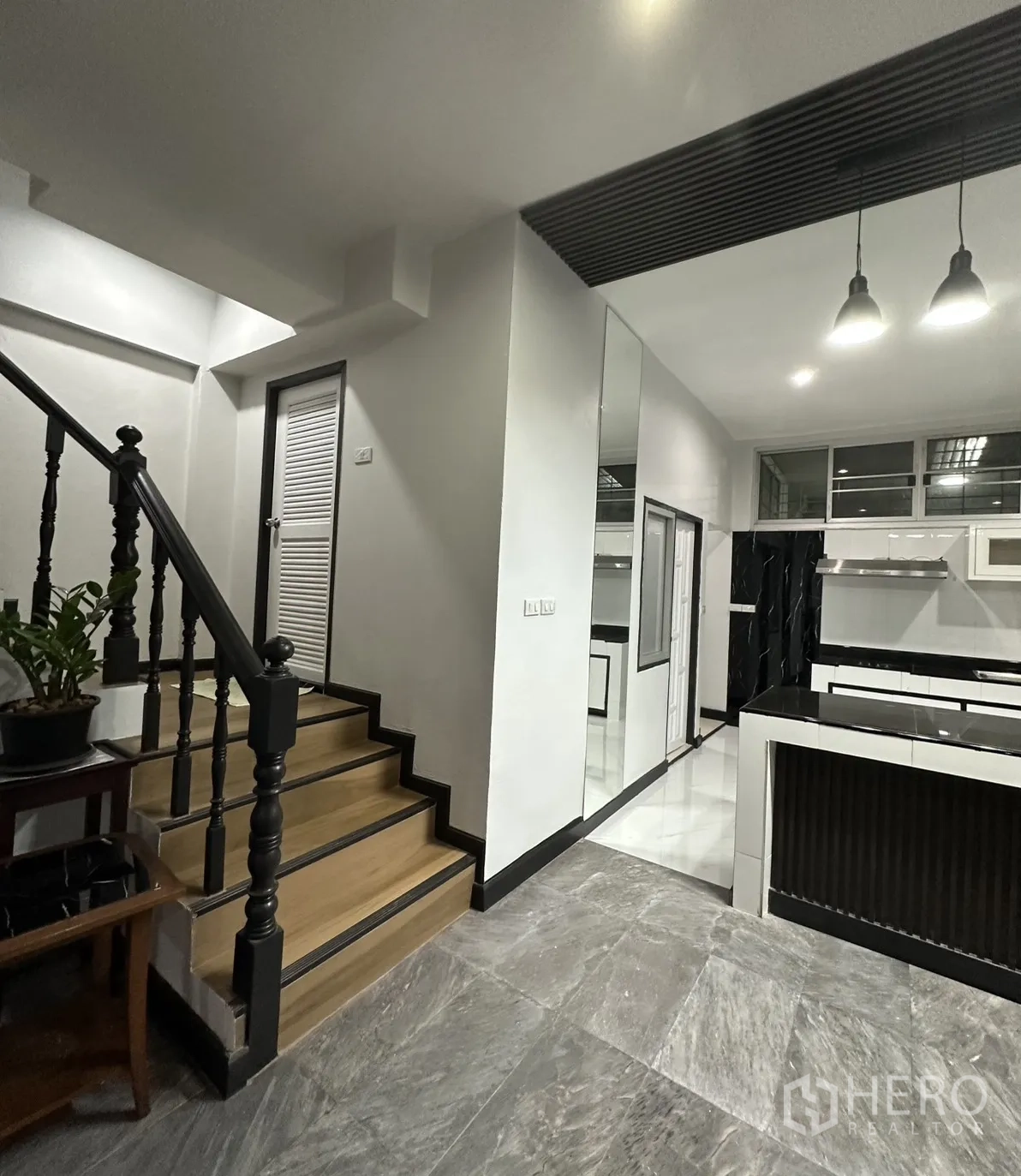 Home Office for rent in Khlong Toei, Bangkok - Staircase beside the kitchen and hallway with mixed tile flooring.