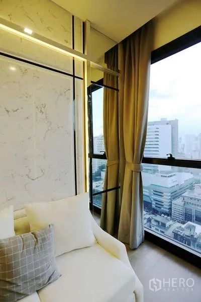 公寓 出租在Watthana, Bangkok - 转角落地窗旁的休息区，纱帘与遮光帘，眺望天际线