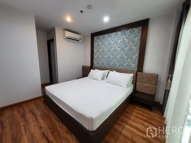 คอนโด ให้เช่าในPhra Khanong, Bangkok - ห้องนอนหลักเตียงคิงส์ ผนังลายดอกไม้ และพื้นไม้โทนอุ่น