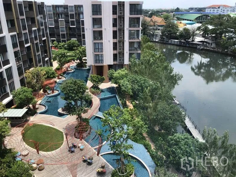 公寓 出租在Watthana, Bangkok - 公寓中庭配度假式蜿蜒泳池、花园绿地，临河景观。