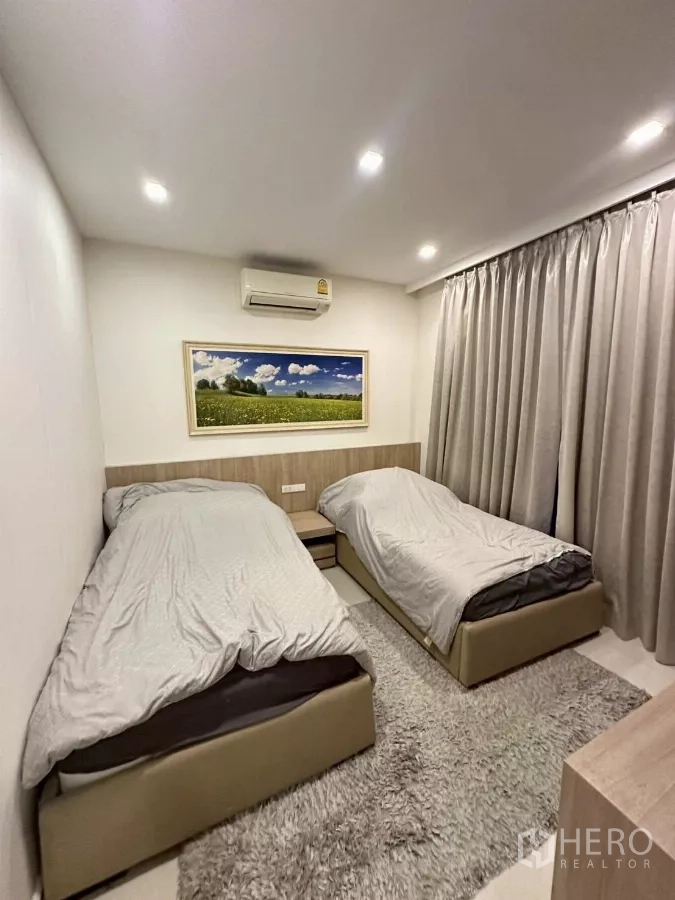 Detached House for sale in Bang Lamung, Chon Buri - Twin bedroom with two single beds and plush rug.