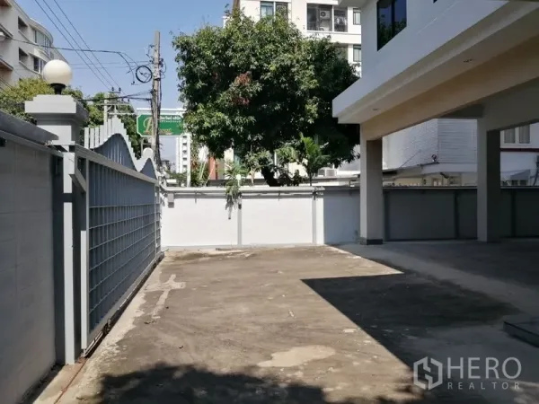 สำนักงานที่บ้าน ให้เช่าในWatthana, Bangkok - ทางรถเข้าและลานจอดรถภายในรั้ว ต้นไม้ใหญ่ข้างอาคาร