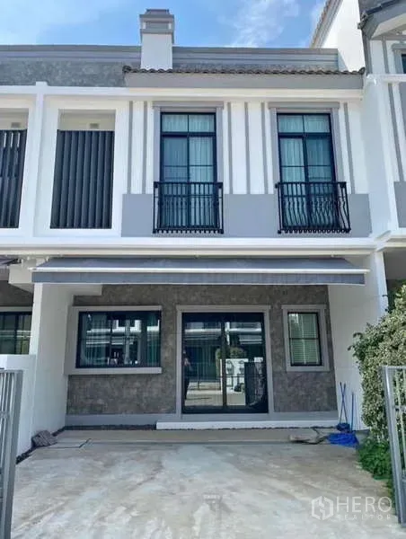 Townhouse for rent in Bang Phli, Samut Prakan - Modern two-storey townhouse exterior with balcony railings and front parking space.