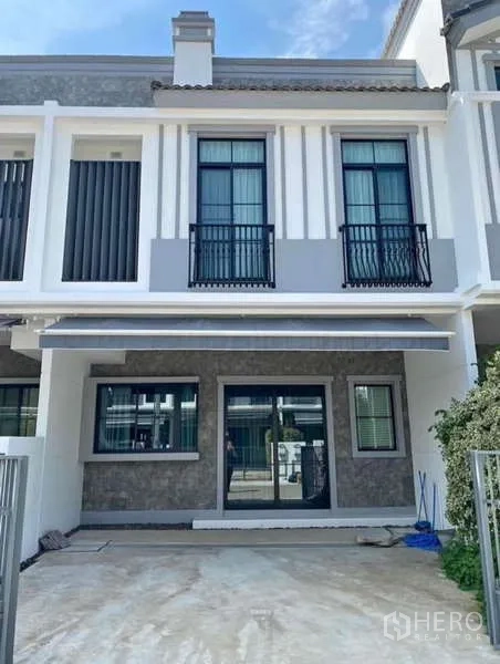 Townhouse for rent in Bang Phli, Samut Prakan - Modern two-storey townhouse exterior with balcony railings and front parking space.