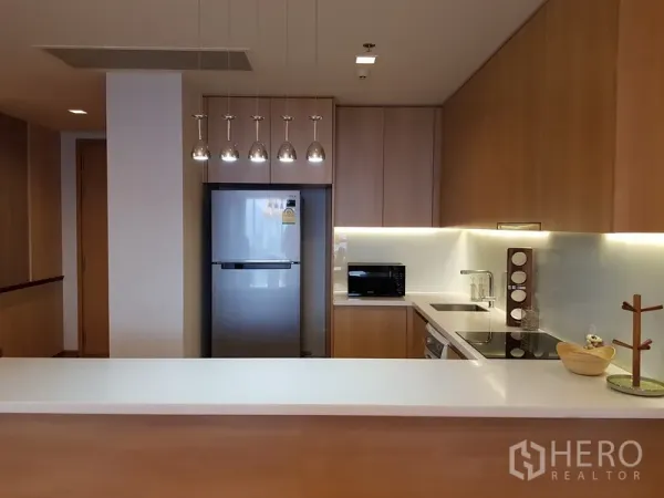 Condominium for rent in Watthana, Bangkok - Modern kitchen with pendant lights, stainless fridge and white countertop
