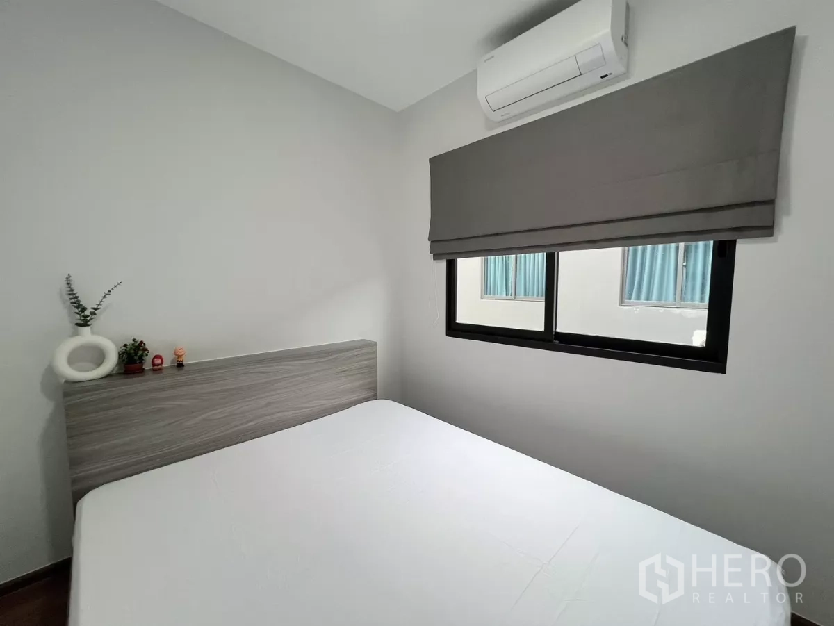 Townhouse for rent in Bang Phli, Samut Prakan - Guest bedroom with window, air conditioner and neutral décor.
