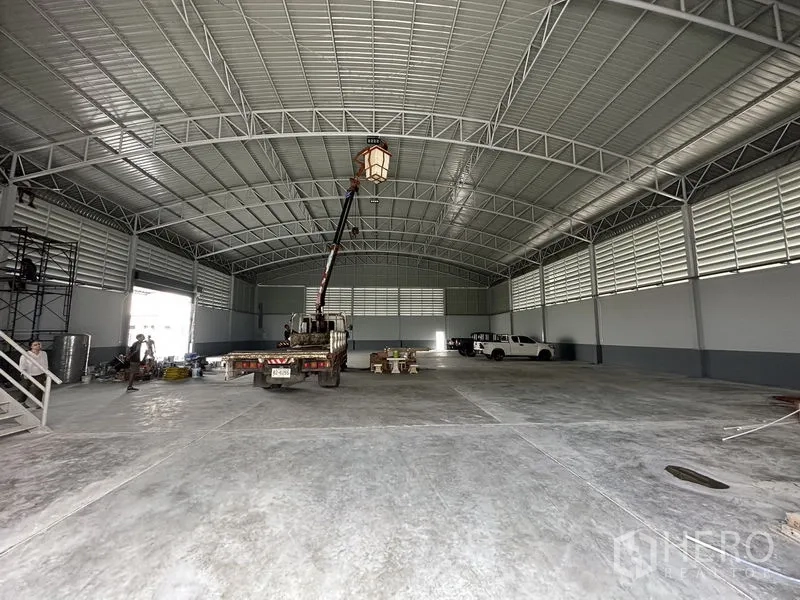 โรงงาน ให้เช่าในPathum Thani - พื้นที่คอนกรีตกว้างของโรงงานพร้อมไฟส่องสว่างกลางฮอลล์และโครงหลังคาโค้ง