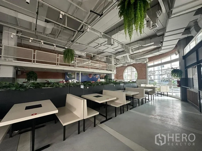 Retail Space for rent in Watthana, Bangkok - Booth seating with planter dividers and hanging plants beneath tall ceilings.