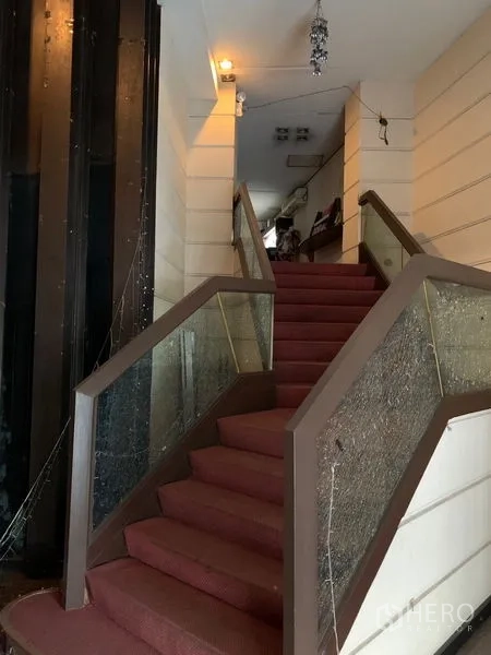 Retail Space for rent in Bang Rak, Bangkok - Red‑carpet staircase with glass balustrade ascending to an upper retail floor.