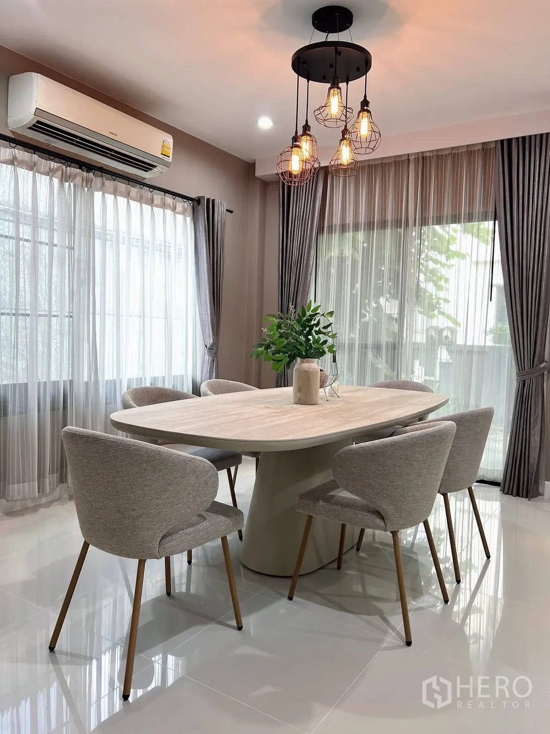 Detached House for rent in Prawet, Bangkok - Dining room with oval table for six under industrial-style pendant lights and big windows.