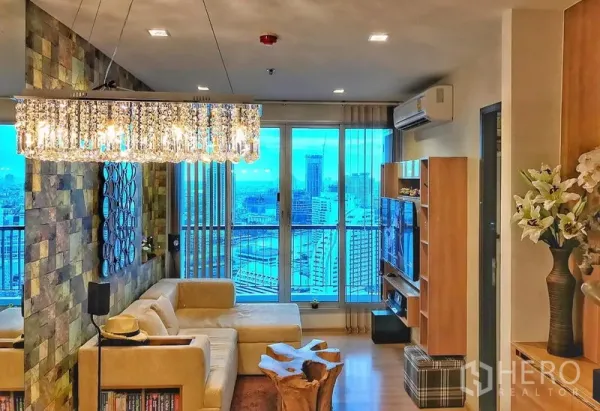 คอนโด ให้เช่าในSathon, Bangkok - ห้องนั่งเล่นสว่าง โซฟาตัวแอล โคมไฟคริสตัล และหน้าต่างสูงชมวิวเมือง