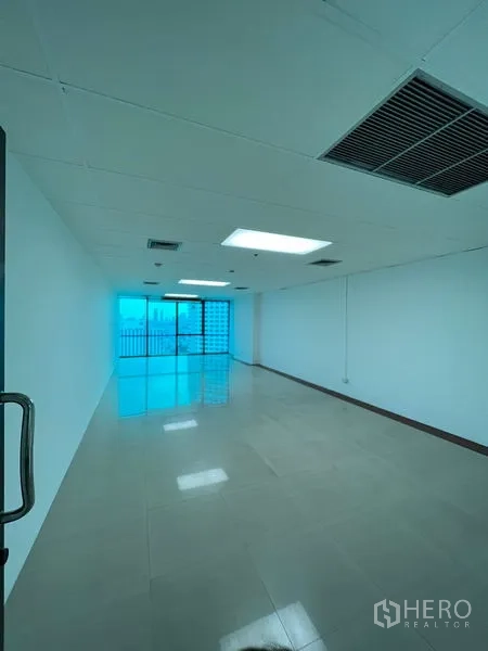 สำนักงาน ให้เช่าในHuai Khwang, Bangkok - สำนักงานแบบเปิดทรงยาว พื้นเงามัน ฝ้าเพดานมีไฟและช่องแอร์ ปลายห้องเป็นประตูกระจกบานเลื่อนออกสู่ระเบียง เห็นวิวเมือง ใกล้ MRT สุทธิสาร
