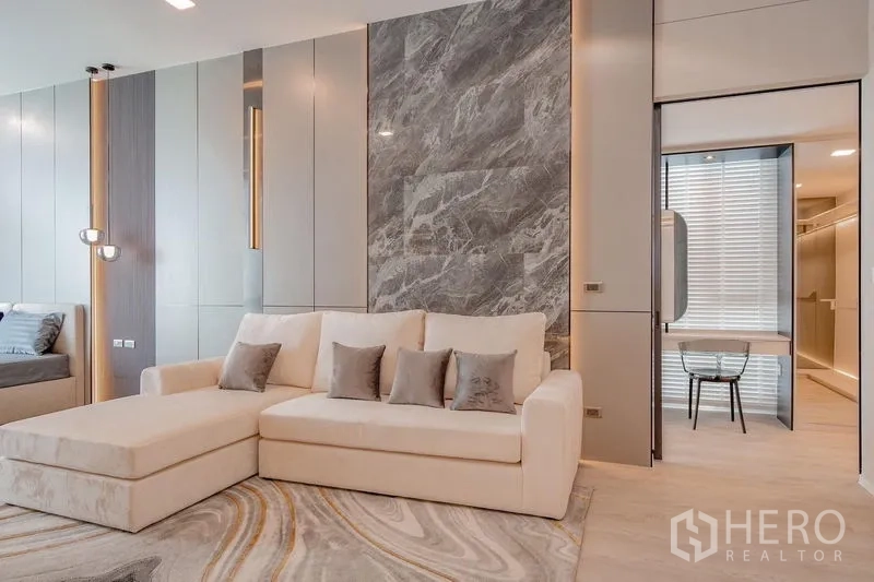 Detached House for rent - Sitting area with cream chaise sofa, marble accent wall and entry to a study.