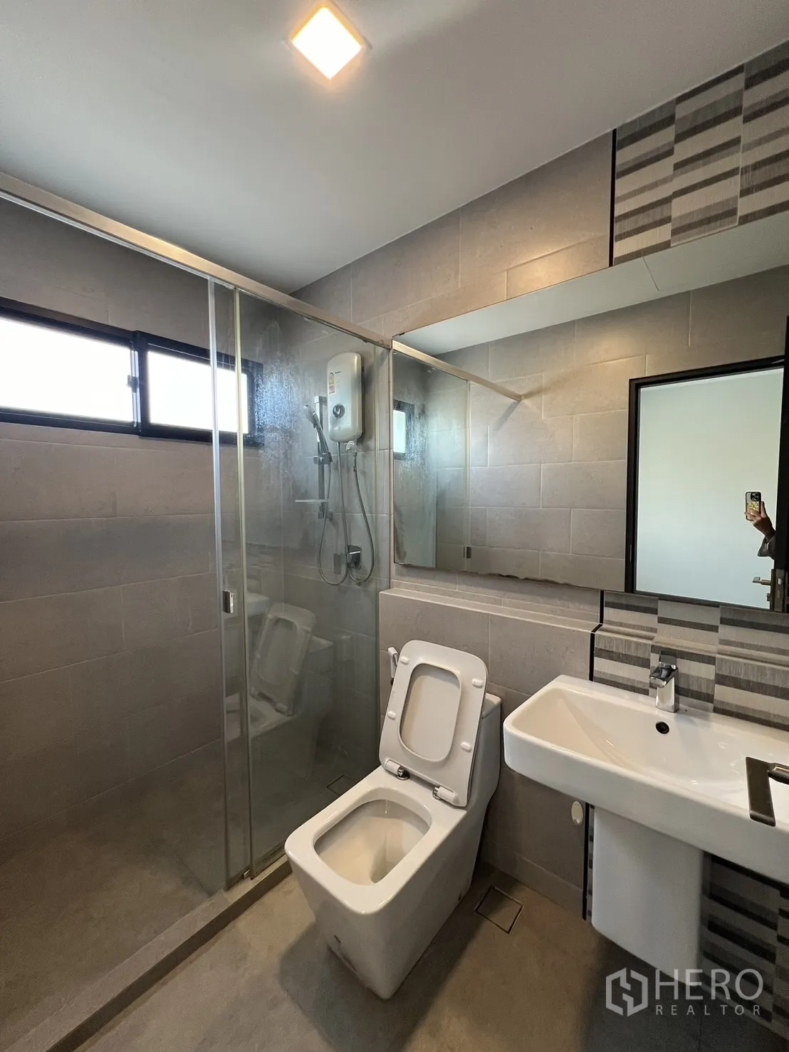 Detached House for rent in Bang Phli, Samut Prakan - Contemporary bathroom with glass shower enclosure, water heater, toilet and basin.