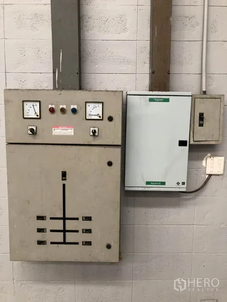 Factory for rent in Pathum Thani - Electrical control panels and meters mounted on a warehouse wall.